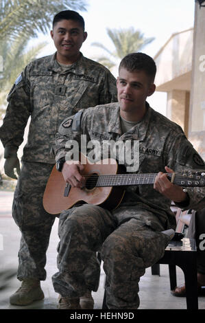 1Lt. John Busuego, un Ontario, California, nativo e 1Lt. Erik Wiesehan, un Canby, Ore., nativo, serenade gli ospiti con acustica e tradizionali canzoni natalizie nella Nahia Rashidiyah, situato a nord-est di Baghdad, durante un barbecue di Natale ospitato da un locale sheik, Dic 26. E Busuego Wiesehan sono membri su embedded locale Team di Ricostruzione del 1° Battaglione, 27 Reggimento di Fanteria "Wolfhound," seconda Stryker Brigade Combat Team 'Warrior", XXV divisione di fanteria, attualmente fissata al 3° BCT, quarto Inf. Div., Divisione multinazionale - Bagdad. Wolfhound barbecue per continuare a Cristo Foto Stock