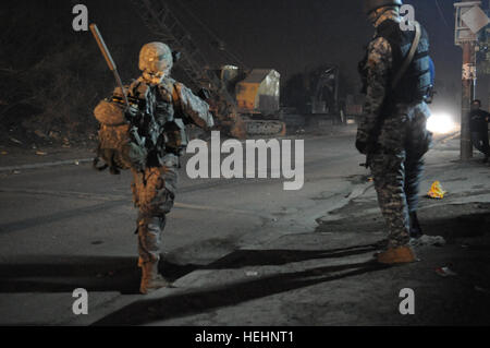 Un iracheno poliziotto nazionale del 8° Brigata, seconda divisione e la U.S. Soldato del 2° Battaglione, 505th Parachute Reggimento di Fanteria, 3° Brigata Team di combattimento, ottantaduesima Airborne Division, guarda il traffico in avvicinamento a un semaforo con un punto di controllo in Muhallah 734, Beladiyat orientale, Baghdad, Iraq, a gennaio 8, 2009. Funzionamento congiunto con la nazionale irachena di polizia sul funzionamento in avanti la fedeltà di Base 144312 Foto Stock