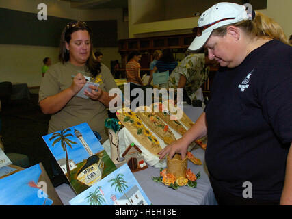 Dianelys Ruiz, un cavo Phoenix dipendente e moglie del Navy Petty Officer 2a classe Ramon Nunez con la base Ufficio Comunicazioni, mostra la sua arte a un cliente a molla fiera artigianale a Windjammer sala da ballo, Marzo 21. Lei e suo marito sono di origine cubana americani che hanno cominciato a lavorare con la ceramica quando sono arrivati a Guantánamo Bay. La loro tabella featured entrambi souvenir di argilla e dipinti dell'isola Joint Task Force Guantanamo Troopers possono acquistare. La molla Fiera Artigianale mette in mostra il talento locale 162531 Foto Stock