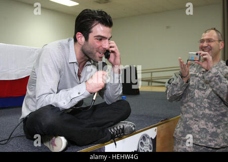 Zachary Quinto, castmember da Star Trek, prendendo una chiamata da un U.S. servicemember della figlia torna negli Stati Uniti solo per dire ciao alla Star Trek Premiere mondiale a Camp Arifjan in Kuwait il 11 aprile 2009. ZacharyQuintoatCampArifjan Foto Stock