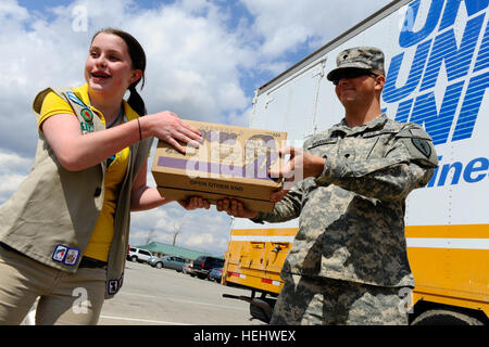 Ragazza Scout Cadet Allie Vescovo, uno studente di Southport Middle School e da un membro del gruppo di ragazze scout 1164, afferra una scatola di Girl Scout cookie da esercito Spc. Giuseppe McQuiddy, 20 Aprile presso il Camp Atterbury, ind. Il Vescovo, insieme con altri deputati di Girl Scouts della centrale indiana, donato più di 38.000 caselle del cookie dolci al Camp Atterbury. Le caselle sarà dato ai membri di servizio intorno al post, comprese quelle di ritorno da e distribuzione di incarichi all'estero. Girl Scout Cookie Drop 166672 Foto Stock