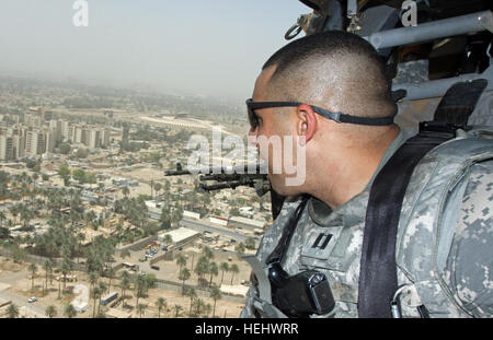 Il cap. Dwayne Hodges, trasporto Officer per l'Area di giunzione del gruppo di supporto - centrale, indagini la città di Baghdad in Iraq attraverso la porta aperta di un UH-60 Blackhawk elicottero come si libra sopra la zona internazionale o IZ, a cui si fa riferimento anche come zona verde, 30 aprile 2009. In fondo è il massiccio Monumento al Milite Ignoto, la più grande struttura di Baghdad. Hodges, un membro del cinquantesimo della brigata di fanteria combattere la squadra, New Jersey Guardia nazionale, è stato in Iraq dal mese di settembre 2008. Volo su Baghdad 169190 Foto Stock