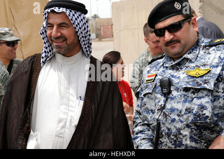 Un Sheikh, che rappresenta una regione di organizzazione sunnita, Sahwa, e un iracheno national police officer di stare in piedi insieme prima di iniziare una riunione per discutere il futuro dei figli di Iraq, in corrispondenza del giunto di sicurezza la fedeltà della Stazione Orientale, Baghdad, Iraq, il 16 maggio. Leadership irachena si riunisce per discutere di figli dell Iraq, altre questioni 175031 Foto Stock