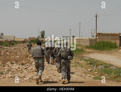 Un interprete e soldati della società B, 2° Battaglione, 112Reggimento di Fanteria, 56th Stryker Brigade Combat Team, muoversi attraverso un Abu Ghraib quartiere, 19 maggio, durante una ricerca di esplosivi di Abu Ghraib. In Pennsylvania Esercito Nazionale soldati di guardia ha collaborato con soldati dell'esercito iracheno per cercare la costruzione e i terreni circostanti in un continuo sforzo per ridurre la minaccia del veicolo a carico ordigni esplosivi artigianali di Abu Ghraib. Guardie, Soldati dell'esercito iracheno a caccia di Abu Ghraib 173741 Foto Stock