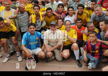 I membri del comune di Iraq e Stati Uniti le squadre di calcio e di tifosi posano per una foto di gruppo tra i giochi del torneo a Sha'ab stadium in Eastern Baghdad, Iraq, il 22 maggio 2009. Stati Uniti I soldati della terza Brigata Team di combattimento, ottantaduesima Airborne Division e nazionale irachena sono poliziotto che partecipano a un pubblico di torneo di calcio sponsorizzato dall'unità FC Organizzazione. Torneo di Calcio a Bagdad 176359 Foto Stock