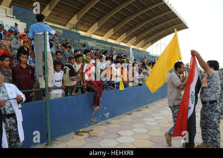 Nazionale iracheno, poliziotti e membri del pubblico iracheno guarda il campo durante un torneo di calcio gioco a Sha'ab stadium in Eastern Baghdad, Iraq, il 23 maggio 2009. Stati Uniti I soldati della terza Brigata Team di combattimento, ottantaduesima Airborne Division e nazionale irachena sono poliziotto che partecipano a un pubblico di torneo di calcio sponsorizzato dall'unità FC Organizzazione. Torneo di Calcio a Bagdad 176405 Foto Stock