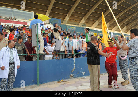 Nazionale iracheno poliziotti, U.S. I soldati e i membri del pubblico iracheno guarda il campo durante un torneo di calcio gioco a Sha'ab stadium in Eastern Baghdad, Iraq, il 23 maggio 2009. Stati Uniti I soldati della terza Brigata Team di combattimento, ottantaduesima Airborne Division e nazionale irachena sono poliziotto che partecipano a un pubblico di torneo di calcio sponsorizzato dall'unità FC Organizzazione. Torneo di Calcio a Bagdad 176407 Foto Stock