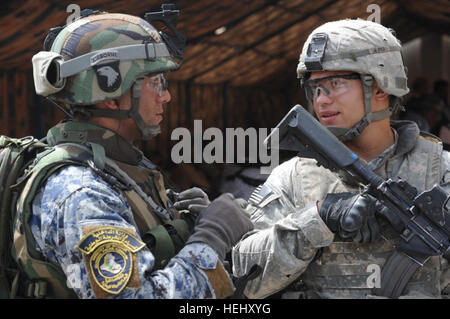 Sgt. Luis Zayas (a destra), di Cleveland, assegnato alla sede centrale e sede società, 2° Battaglione, 505th Parachute Reggimento di Fanteria, 3° Brigata Team di combattimento, ottantaduesima Airborne Division, Division-Baghdad multinazionali, parla di un poliziotto nazionale durante la fase di apertura della al-Ameen stazione di polizia, 27 maggio, nella 9 Nissan distretto orientale di Baghdad. Dell'Iraq il ministro degli Interni, Jawad AL-Bolani e il senior usa e sicurezza irachena funzionari nel quartiere erano anche di presenze per la cerimonia. Paracadutisti frequentare la polizia irachena di apertura della stazione di al-Ameen 175390 Foto Stock