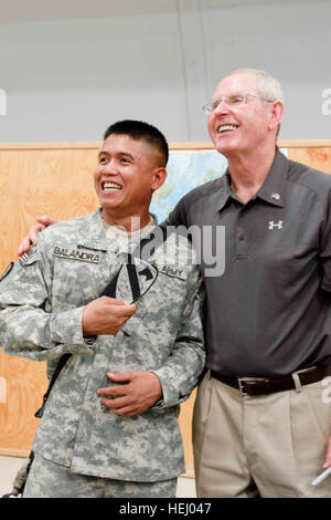 Sgt. Jeffery Balandra, con un Co., 3° Battaglione, 8 reggimento di cavalleria, 3° 'Graywolf' Heavy Brigade Combat Team, 1a divisione di cavalleria in posa per una foto tenendo premuto il manicotto spalla insegne aveva firmato da Tom Coughlin, la National Football League head coach della New York Giants, che ha visitato le truppe in avanti una base operativa Marez luglio 2 come parte di un tour del paese da lui e altri quattro pullman di NFL. Army.mil-44636-2009-07-12-110707 Foto Stock