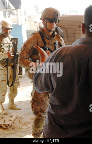 Un fornitore locale di colloqui con 1Lt. Steven Kelly (centro), un comandante di plotone da Marion, Ind. assegnato alla società D, 1° Battaglione, 505th Parachute Reggimento di Fanteria, 3° Brigata Team di combattimento, ottantaduesima Airborne Division, come un esercito iracheno Soldier guarda durante un pattugliamento comune in un mercato nel sud-est di Bagdad, 18 agosto. Big Dawgs cercare risposte a trovare amici 197474 Foto Stock