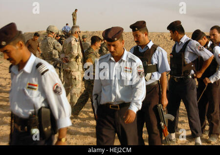 Membri della Mamma poliziotti iracheni la linea fino a ottenere le munizioni a un poligono di tiro in Mamma, Iraq, 11 agosto. Stati Uniti I soldati della 218th Polizia Militare Company, 1° Divisione di cavalleria, 2° Brigata Team di combattimento, fornire la formazione per contribuire a migliorare l'IP della capacità di cottura. Giorno sul poligono di tiro 199727 Foto Stock