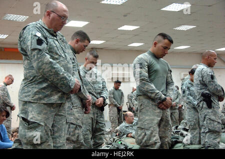 Stati Uniti Soldati, assegnato alla cinquantaseiesima Stryker Brigade Combat Team, ventottesima divisione di fanteria, Pennsylvania National Guard, Divisione multinazionale - Bagdad, prua le loro teste in una rapida preghiera prima di lasciare il Camp Taji, Iraq, Sett. 6. Essi fanno parte dell'ultima grande gruppo di 56th SBCT soldati per lasciare Taji dopo otto mesi di tour in Iraq. In Pennsylvania Guardia Nazionale parte 205321 Foto Stock