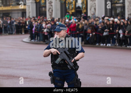 Polizia armata fornire protezione durante il cambio della guardia al di fuori Buckingham Palace, London, England, Regno Unito Foto Stock