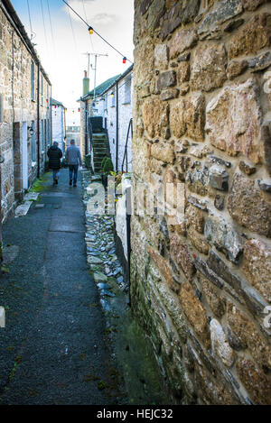 Un paio di piedi verso il basso i pittoreschi Duck Street nel villaggio storico di Mousehole, Cornwall. Foto Stock