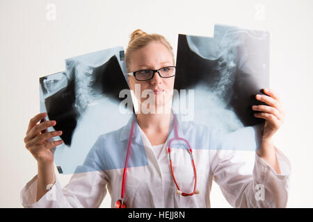 Regno Unito i professionisti sanitari : un servizio sanitario nazionale (NHS) femmina donna dottore guardando un set di immagini a raggi X Foto Stock