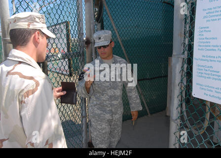 GUANTANAMO Bay a Cuba - Esercito Spc. Kevinn'tardi, destra, un poliziotto militare con la Joint Task Force Guantanamo 480th della Polizia Militare Company, controlla il badge di sicurezza della marina militare di un organo di servizio a un campo di detenzione, 6 ott. 2009. Il 480th MP Company, parte della 525th Polizia Militare battaglione, fornisce la sicurezza nei campi. JTF Guantanamo conduce al sicuro, umano, legale e trasparente di cura e custodia dei detenuti, compresi quelli condannati dalla commissione militare e quelli ordinati rilasciato da un tribunale. La JTF conduce la raccolta di intelligence, analisi e diffusione per la protezione di det Foto Stock