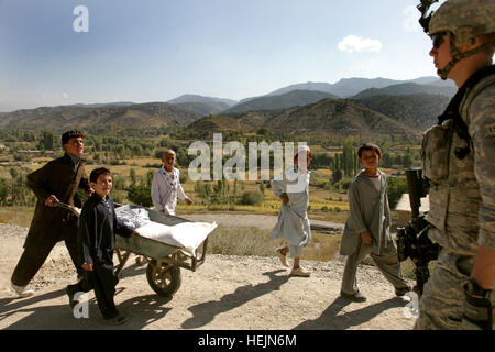 Stati Uniti Army Spc. Scott Walker da Elkin, N.C., a piedi davanti a un gruppo di ragazzi afghani durante una pattuglia con il suo plotone da combattimento vicino avamposto Herrera, Paktiya provincia, Afghanistan, 13 ottobre, 2009. Il camminatore è distribuito con Apache truppa, 1° Stormo, quarantesimo reggimento di cavalleria. Soldati Patroling Campagna 213188 Foto Stock