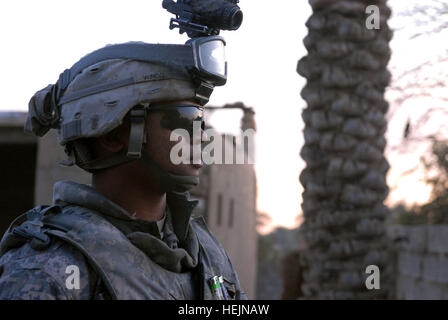 Un soldato con la società C, 3° Battaglione, XXI Reggimento di Fanteria, 1° Stryker Brigade Combat Team, XXV divisione di fanteria, guarda fuori del cancello anteriore di un iracheno a una stazione di polizia nella provincia di Diyala in Iraq mentre i suoi sottufficiali di soddisfare con la IPs all'interno per discutere di pattuglie di prossima uscita. L'inizio della fine di un periodo di disordini tra odierna soldati a piedi 151652 Foto Stock