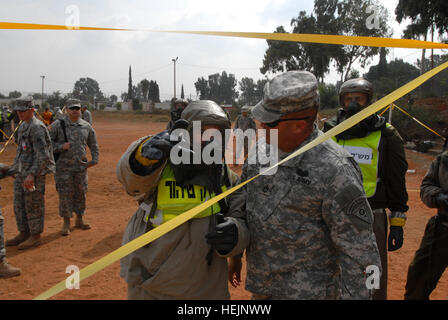 Un soldato da israeliano Home anteriore del comando 945th nucleare, biologico e chimico battaglione, Dan District, discute di zona calda e fredda con procedure di Ohio Army National Guard Sgt. 1. Classe David Nickerson ott. 21, 2009, durante una dimostrazione di decontaminazione di procedure di truppa. Nickerson è il sottufficiale in carica dell'Ohio Guardia nazionale della chimica, biologica, radiologica, nucleare e ad alta resa migliorata esplosiva Response Force team che ha nove membri in Israele per la formazione congiunta esercizio Juniper Cobra 10, coinvolgendo i militari israeliani e Home Front Comm Foto Stock