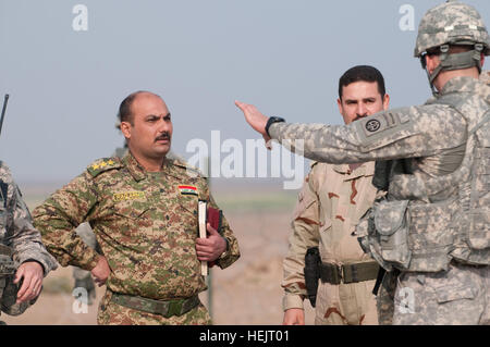 Il cap. Mohanad, Operations Officer per 3° Battaglione, vigili del 1°, 1° esercito iracheno divisione, basata a combattere avamposto Hawas, Al Anbar provincia, Iraq, saluta i paracadutisti con la società A, 2° Battaglione, 504th Parachute Reggimento di Fanteria, 1° Brigata, ottantaduesima Airborne Division (Consigliare e assistere la brigata), come gli americani prepararsi a scendere un carico-scanning "backscatter van' a un semaforo con un punto di controllo, nov. 20, 2009. L'Aab sta distribuendo i furgoni per aiutare le forze di sicurezza irachene a sventare il traffico di armi e di esplosivi nella corsa fino a febbraio 2010 elezioni nazionali. Paracadutisti installare veicolo S Foto Stock