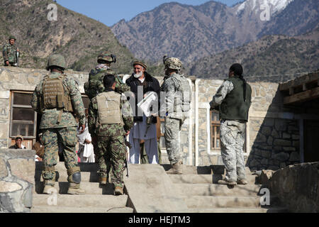 Stati Uniti Esercito Capt. Albert 'Paco' Bryant, da Washington, D.C., Marine Capt. Marcus giovani, dal Maryland, e l'Esercito nazionale afgano i soldati si incontrano con il quartiere Shigal sub-governatore presso il villaggio di Lachey nella provincia di Kunar, Afghanistan il 7 dicembre. Bryant è il comandante di compagnia di combattimento, 1° Battaglione, XXXII Reggimento di Fanteria, 3° Brigata Team di combattimento, decima divisione di montagna e giovani è incorporato il Team di training del comandante. OperationEnduringFreedom-SGTTeddyWadePhotographs-01 Foto Stock