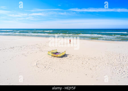 Unidentified giovane donna in costume da bagno a piedi fuori dal mare sulla spiaggia di sabbia in Bialogora, Mar Baltico, Polonia Foto Stock