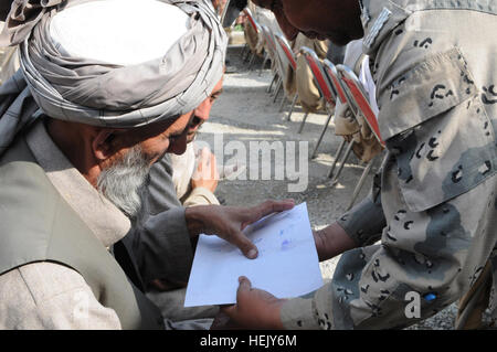 Un anziano tribale, assistita da un confine afghano funzionario di polizia, pone la sua impronta sulla sua firma, accettando i mandati di un anti-Taliban patto Shinwari durante un tribale Shinwari meeting per la pace e l unità in Afghanistan orientale della provincia di Nangarhar, gen. 21. Più di 170 Maliks, o gli anziani del villaggio si sono incontrati per la tradizionale consiglio afgano ospitato dal confine afghano polizia sesto Kandak nel distretto di Shinwar. La Shinwari sub-tribù si sono riuniti per manifestare la loro unità per fornire la sicurezza e garantire la progressione economica nelle loro comunità. Afghan Polizia di frontiera si incontrano con Shinwari agli anziani di Prot Foto Stock