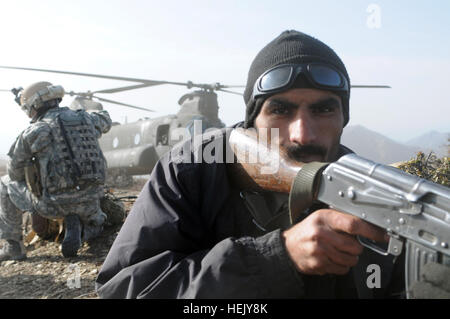 Un confine afghano funzionario di polizia assegnato alla provincia di Nangarhar 6 scansioni Kandak il perimetro durante un assalto aereo missione presso un avamposto afghano nei pressi di un Afghanistan/Pakistan confine di montagna in Nazyan. Il giunto Afghan/funzionamento della coalizione è stato uno spettacolo di unità a potenziali pirati informatici. Afghan della Polizia di frontiera e la Task Force pilota irregolare funzionamento completo di montagna 251309 di consegna Foto Stock