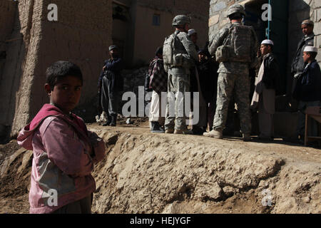 Stati Uniti I soldati dell esercito e della polizia nazionale afgana parlare con anziani locali come i bambini stanno a guardare in meraviglia nel villaggio di Mongow Khel, provincia di Logar, Afghanistan, 2 febbraio. Parlando con gli anziani consente di ottenere importanti informazioni sulla zona mentre il rafforzamento delle relazioni con la popolazione locale. MP il comportamento della pattuglia smontati 246939 Foto Stock