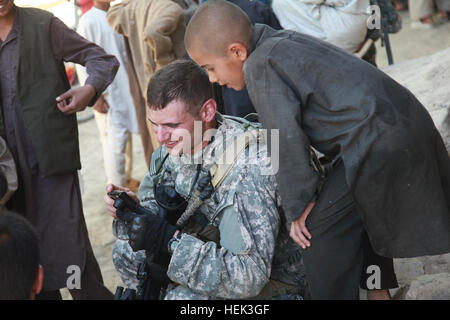 Afghan ragazzi guardare la fotocamera di un U.S. Soldato che solo recentemente ha preso una foto di loro. Membri dalla Task Force Wolverine condotta una pattuglia smontati attraverso il bazaar di Bagram per trovare informazioni dal recente attacco su Bargam Airfield, Parwan provincia, Afghanistan, 24 maggio. Patrol attraverso il bazaar di Bagram 283338 Foto Stock