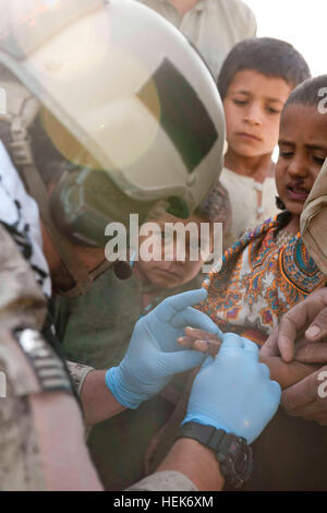 Un U.S. Le forze speciali medic tratta un trascurato gash sulla mano di un ragazzo afgano durante una pattuglia di poliziotti dal 2° Battaglione, 3° nazionale afghano di ordine civile di polizia e dei vigili del fuoco nella provincia di Kandahar del distretto di Zhari, Ottobre 22, 2010. Poliziotti con 2 miliardi di euro. sono abbinate con i membri delle Operazioni Speciali Task Force - Sud. Nazionale Afghano di ordine civile pattuglia di polizia distretto di Zhari 332614 Foto Stock