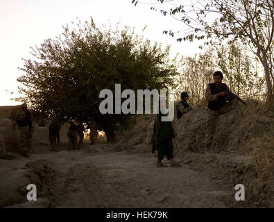 Poliziotti con 2° Battaglione, 3° nazionale afghano di ordine civile di polizia, vigili del parlare con un ragazzo afgano durante un tardo pomeriggio patrol nov. 6, 2010, CON GLI STATI UNITI Le forze speciali nel distretto di Zhari, provincia di Kandahar, Afghanistan. Il ANCOP dalla 2bn. sono abbinate con i membri delle Operazioni Speciali Task Force - Sud. La notte scende sulla polizia afgana, sicurezza presenza continua 340482 Foto Stock