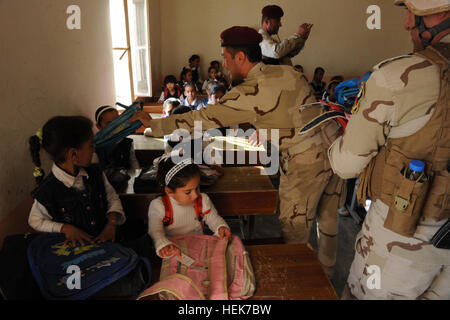 Soldati dell'esercito iracheno con 8 esercito iracheno brigata distribuire zaini per la scuola irachena i bambini in Habbaniyah, Iraq, nov. 10. I soldati degli Stati Uniti assegnato al 3° Battaglione, 7° Reggimento di Fanteria, quarta brigata, terza divisione di fanteria ha osservato e assistiti soldati dell'esercito iracheno nella distribuzione di zaini riempiti con forniture scolastiche per i bambini iracheni a tre diverse scuole a sostegno dell'operazione nuova alba. Zaini 344708 Foto Stock