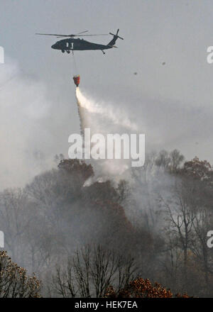 Un elicottero Blackhawk scende approssimativamente 600 galloni di acqua da un pieghevole secchio d'acqua per estinguere un brushfire a Camp Atterbury manovra comune centro di formazione nov. 12. Il fuoco è stata contenuta nella zona di impatto senza danni alla proprietà. Camp Atterbury Douses fiamme sul range 339611 Foto Stock