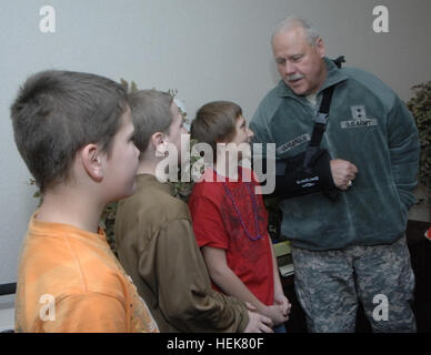 L'Indiana aiutante generale; il Mag. Gen. R. Martin Umbarger parla con gli studenti elementari Zackery Albright; Brandon Albright; e Giosuè Shepard; mentre visitano Stout Campo Scuola elementare; presentare il selezionare alcuni con nuovi cappotti e la sua sfida moneta come parte del 'calde mani; riscaldare i cuori' programma; Dic. 6; 2010. Ogni anno l'Indiana National Guard per i dipendenti che lavorano sul campo Stout raccogliere fondi per donare tempo freddo elementi al campo Stout studenti elementari per la 'calde mani; riscaldare i cuori' programma. Migliora la vita una mano in un momento 347577 Foto Stock