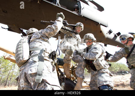 Paracadutisti aiutare la loro battaglia buddy salire da un pezzo di artiglieria dopo averlo agganciato fino ad un UH-60M Black Hawk elicottero durante un esercizio di campo tra la ottantaduesima Airborne Division il primo combattimento vigili del Team e la sua lotta contro la brigata aerea 2 Febbraio, a Fort Bragg, N.C. I paracadutisti ritiro per la woodline prima dell'elicottero ascensori obice nell'aria. Il veterano della unità di artiglieria relearns air assault competenze 367687 Foto Stock