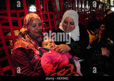 Il 9 marzo 2011 le famiglie egiziane a prepararsi per la lunga lotta da Djerba Zarzis Airport in Tunisia al Cairo, Egitto a bordo di una U.S. Air Force C-130J. Questi cittadini egiziani sono tra decine di migliaia di persone che sono fuggiti dal conflitto in Libia in Tunisia, in cui la crisi umanitaria è il dispiegamento. Questo C-130J, percorsa dalla 37th Airlift Squadron da Ramstein Air base, Germania, è parte di un contingente di aeromobile da la 37th e la 26th U.S. Marine Expeditionary Unit che stanno ricevendo gli sfollati home. Poiché le operazioni ha cominciato il 4 marzo, più di 750 passeggeri sono stati spostati al Cairo. Il airlif Foto Stock