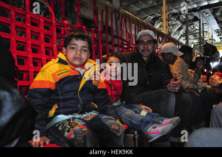 Il 9 marzo 2011 le famiglie egiziane a prepararsi per la lunga lotta da Djerba Zarzis Airport in Tunisia al Cairo, Egitto a bordo di una U.S. Air Force C-130J. Questi cittadini egiziani sono tra decine di migliaia di persone che sono fuggiti dal conflitto in Libia in Tunisia, in cui la crisi umanitaria è il dispiegamento. Questo C-130J, percorsa dalla 37th Airlift Squadron da Ramstein Air base, Germania, è parte di un contingente di aeromobile da la 37th e la 26th U.S. Marine Expeditionary Unit che stanno ricevendo gli sfollati home. Poiché le operazioni ha cominciato il 4 marzo, più di 750 passeggeri sono stati spostati al Cairo. Il airlif Foto Stock