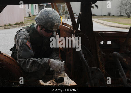 Stati Uniti Army Sgt. Mike Huettel con la Alabama National Guard 666th della Ordnance Company (l'eliminazione degli ordigni esplosivi) raccoglie le testimonianze di una veicolo distrutto durante le operazioni in ambiente urbano la formazione a Fort McClellan, Ala., Febbraio 2, 2013. (U.S. Esercito foto di PFC. Geremia Raines/RILASCIATO) l'eliminazione degli ordigni esplosivi esperti treno per raccogliere prove 130202-A-GA328-002 Foto Stock