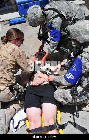 Canadian army medical tecnico, Cpl. Pamela Plante (sinistra), assegnato al quinto campo ambulanza, 5 campo Gruppo di assistenza basati fuori Valcartier, Quebec, Canada e Stati Uniti Air Force Senior Airman Stacy John (centro), assegnato a 721st delle forze di sicurezza Squadron, Cheyenne Mountain, Co., Air Force Station; e U.S. Air Force Senior Airman Avery marrone (a destra), assegnato a 48th delle forze di sicurezza Squadron, Royal Air Force Lakenheath, Inghilterra, fornire un primo aiuto a un incidente di massa esercita su di Kandahar Airfield, 21 giugno. L'esercizio è stata condotta dalla forza internazionale di assistenza alla sicurezza militare e di polizia medic Foto Stock