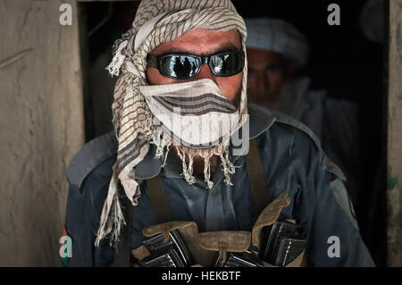 Provincia di Nangarhar, Afghanistan - al fine di proteggere la sua identità, afghane uno poliziotto indossa una sciarpa mentre ricerca case nel distretto di Kot, provincia di Nangarhar, Afghanistan orientale, 19 luglio. Mentre il CDS ricerca per armi e ordigni esplosivi artigianali, soldati di truppa C, terzo squadrone, 4° reggimento di cavalleria, Task Force Raider, 3° Brigata Team di combattimento, XXV divisione di fanteria, Task Force Bronco ha fornito sicurezza durante il funzionamento. (Foto di U.S. Army Sgt. 1. Classe Mark Burrell, 210th MPAD) afghane, le forze della coalizione hanno partnership migliora le pattuglie 110719-A-GX923-076 Foto Stock