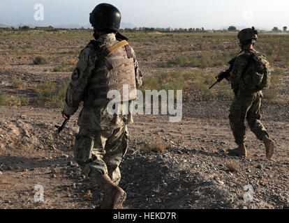 Provincia di Kandahar, Afghanistan (sett. 4, 2011) -- i membri della seconda nazionale afghano di ordine civile di polizia team SWAT e la Task Force Thunder Kandahar Pathfinder distacco condurre una pattuglia sett. 4. Presenza di pattuglie dare le unità un opportunità di interagire con la popolazione locale e costruire un rapporto con il popolo, mentre dà anche la ANCOP l opportunità di mettere in pratica alcuni dei loro fondamentali tecniche operative. Il team SWAT è considerato uno dei più elite delle forze di sicurezza afgane. I suoi membri ricevono armi speciali e operazioni tattiche di formazione che consente loro di pianificare e particol Foto Stock