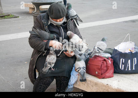 Roma, Italia. Il 22 dicembre 2016. Una donna che alimenta un gruppo di piccioni affamati seduta sul suo giro nel centro di Roma Credito: amer ghazzal/Alamy Live News Foto Stock