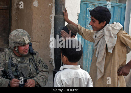 La città di Kandahar, Afghanistan (sett. 30) - Staff Sgt. Gordon Williams, un poliziotto militare con 58th Polizia Militare azienda attaccata al 2° Brigata Team di combattimento, 4a divisione di fanteria, parla inglese con giovani ragazzi afghani dalla polizia sotto la stazione 16 comunità, che vogliono mostrare le loro abilità, Sett. 30. Williams e il suo plotone membri insieme con loro Afghan uniforme della polizia sono stati partner che circola attraverso la comunità per capire meglio i bisogni della gente e le preoccupazioni. (U.S. Esercito foto di Spc. Aprile York, seconda BCT, quarto Inf. Div., PAO) Gioventù 110930-A-QO451-015 Foto Stock