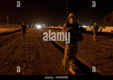 Poliziotti militari assegnati alla società di sede, 2° Brigata truppe speciali Battaglione, 2° Brigata, ottantaduesima Airborne Division, condurre una pattuglia smontati lungo una strada fuori dal Camp Taji, Iraq, Dic. 2. La MPs arrotolato a lungo prima di sunrise per pattugliare le strade al di fuori del campo per garantire la sicurezza di 2/82 di convogli che viaggiano attraverso la zona da Baghdad. La seconda brigata è l'ultimo dei vigili del fuoco a Bagdad ed è facilitare il ritiro degli Stati Uniti per le forze militari da Iraq. Manovra e mobilità, la polizia militare instradamenti sicuri a Bagdad 494379 Foto Stock