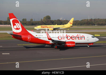 Dusseldorf, Germania - 21 Ottobre 2011: Un Air Berlin Boeing 737-800 e TUIfly Boeing 737-700 taxi all'aeroporto di Düsseldorf (DUS) in Germania. Aria Berl Foto Stock