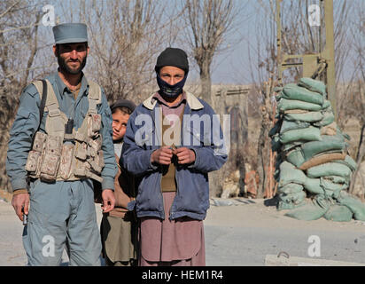 Afghane uno poliziotto e bambini afgani guardare la fotocamera in pul-e Alam, provincia di Logar, Afghanistan, 11 genn. 2012. Pul-e Alam 120111-A-BZ540-025 Foto Stock