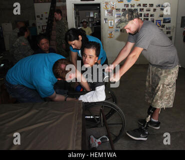 Spc. Evan Marcy, un veterano di combattimento in precedenza con 55th Signal Company, e terapia fisica studenti laureati presso la California State University di Northridge assiste un paziente in una nuova sedia a rotelle personalizzate. Marcy ha lavorato con gli studenti da Northridge a Hope Haven Guatemala per personalizzare carrozzine per bambini e assistenza a quei pazienti che hanno disabilità fisiche e mentali come la scoliosi e paralisi cerebrale. HSV-2 Swift-Southern stazione di partenariato 2012 120112-A-IP644-416 Foto Stock