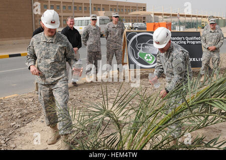 Brig. Gen. Jonathan G. Ives (sinistra), comandante generale, 346 Supporto comando (Expeditionary), Washington Esercito Nazionale Guardia, e il tenente Col. Fredrick Bower (a destra), vice comandante, Area di supporto supporta Group-Kuwait Giornata della Terra versando acqua riciclata su due piantate data palme qui il 22 aprile. La data le palme sono state donate da telefono internazionale e del telegrafo e ASG-ku. Gli alberi piantati darà i suoi frutti e produrre sei prole di palme da dattero per essere piantato qui. Terza Armata è modellare il futuro di preservare e mantenere l'ambiente pulito e salutare in tutta la sua area Foto Stock