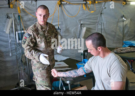 Sgt. David Sudduth, Un medico tecnico di laboratorio con il sangue 440th distacco, Fort Sam Houston, Texas, si prepara a prelevare il sangue dal 1 Lt. Daniel Brown, combinata Task Force Arrowhead, Aprile 26, 2012. Essendo un donatore di sangue in teatro è molto importante; sarà sicuramente a salvare vite umane, detto Sudduth. (U.S. Esercito foto di Sgt. Chris McCullough, combinata Task Force Arrowhead Affari pubblici) da un soldato a un altro; i donatori di sangue sono sempre nel bisogno 120427-A-ET795-012 Foto Stock